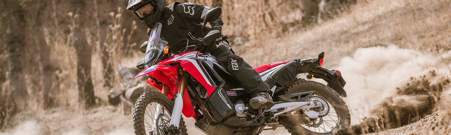 A rider going down a trail on a 2019 Honda XR650L dirt bike. 